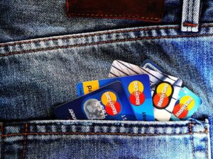 Several credit cards tucked into the back pocket of blue jeans