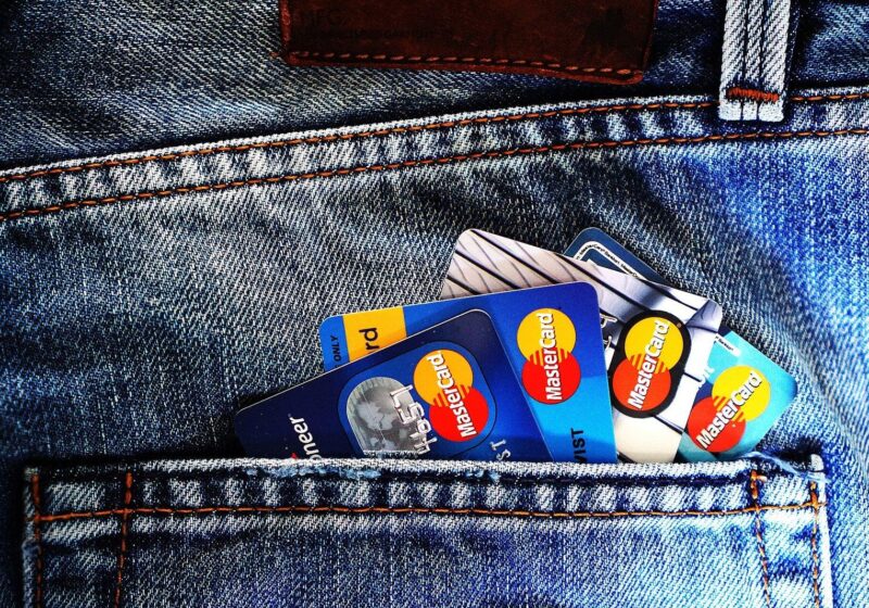 Several credit cards tucked into the back pocket of blue jeans